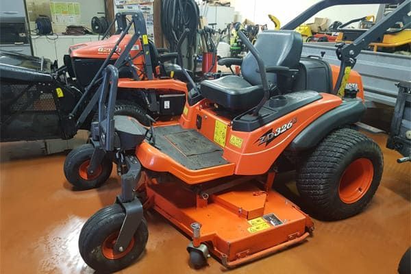 Tondeuse à gazon à rayon de braquage zéro Kubota orange dans un atelier, vue en angle.