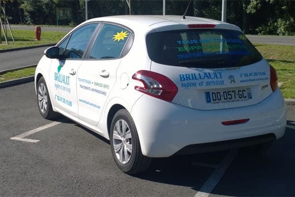 Voiture d'auto-école Peugeot 208 blanche garée sur une place de parking.