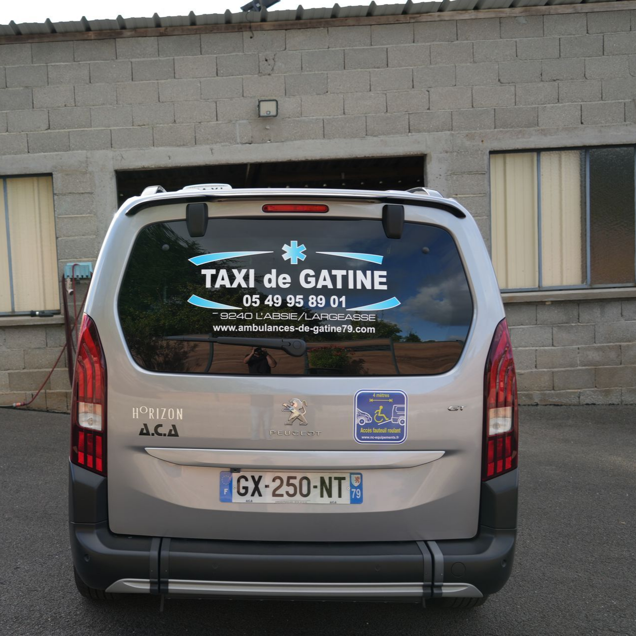 Vue arrière d’un taxi gris stationné devant un bâtiment