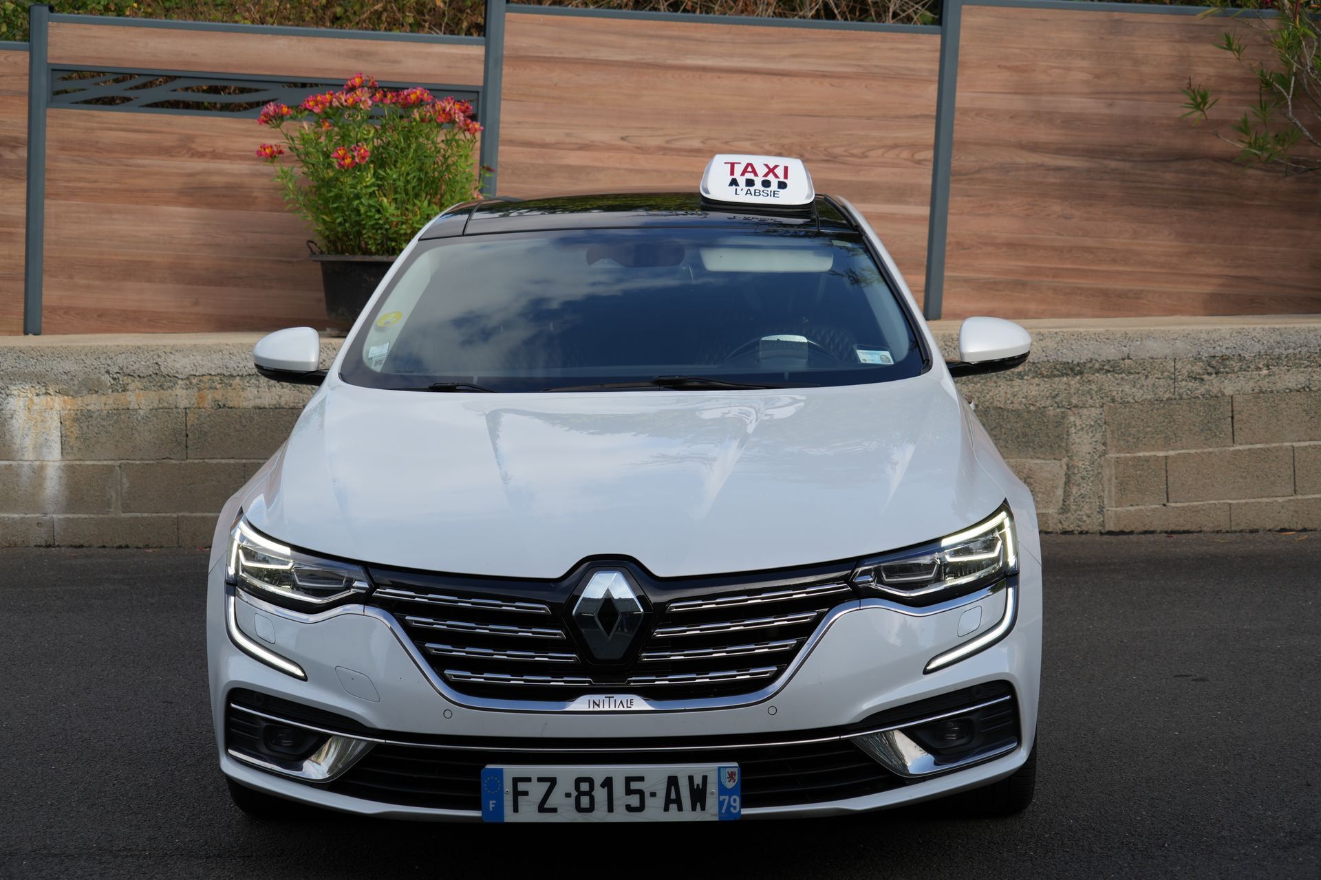 Une main ouvre la portière arrière d'une voiture noire.