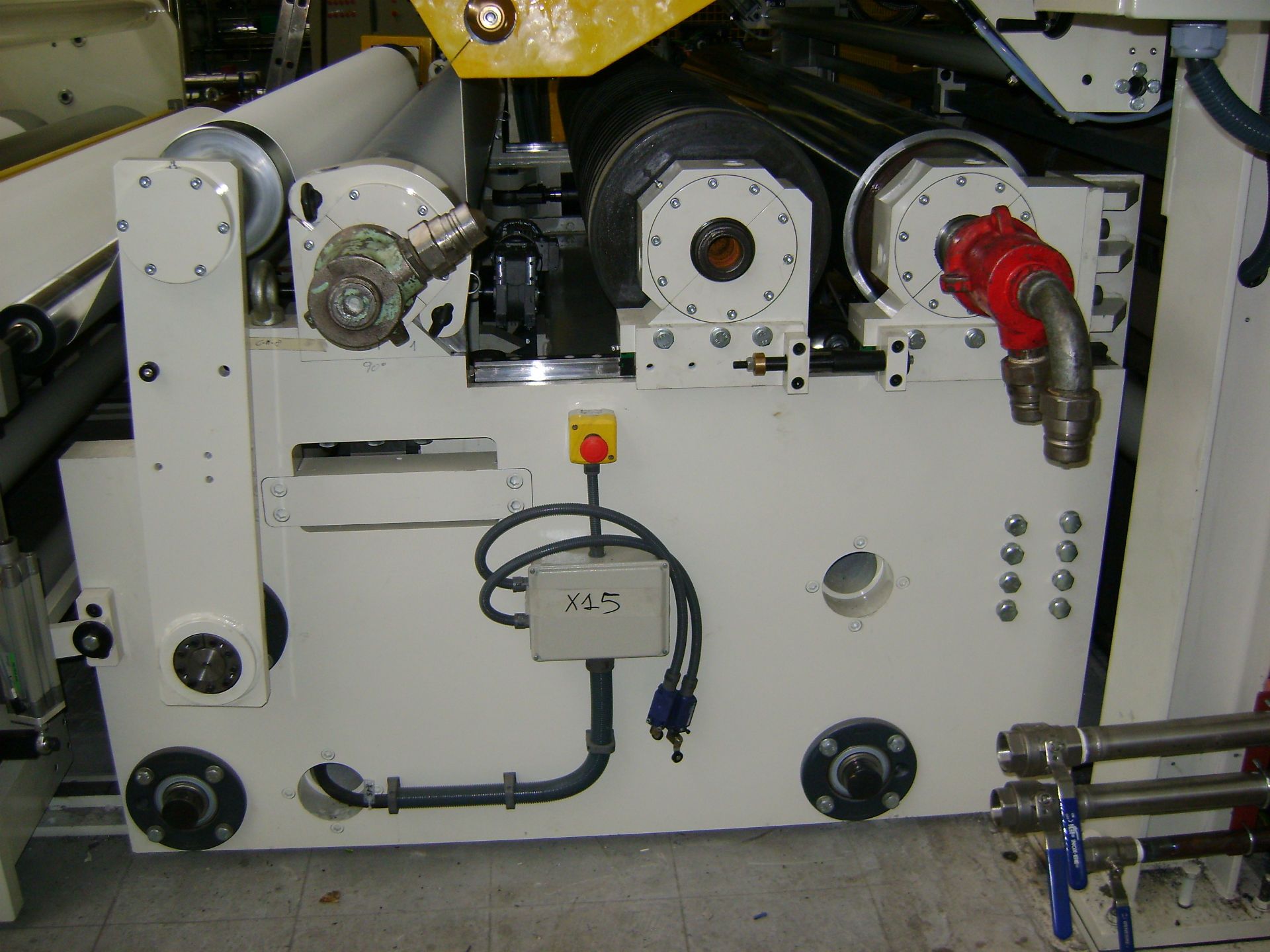 Una máquina blanca con una parte superior amarilla está sobre un suelo de baldosas.