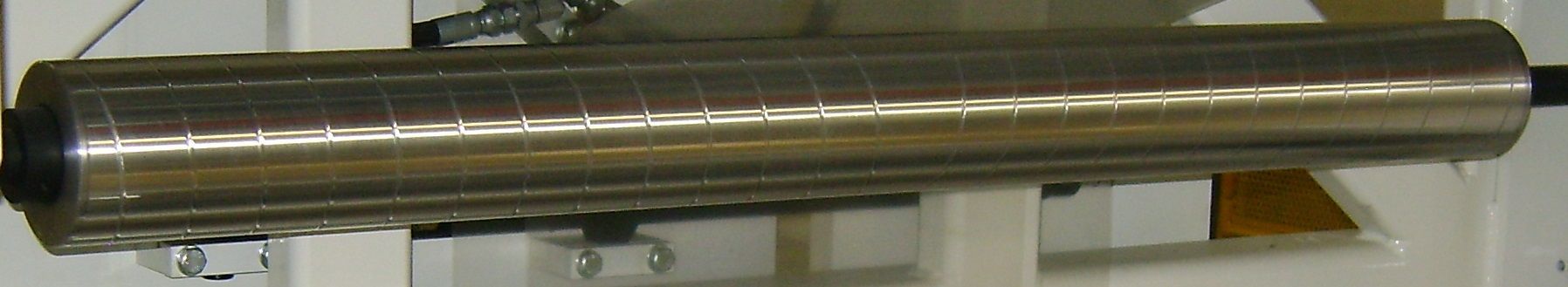 Un gran tubo de metal está sobre una mesa de madera.