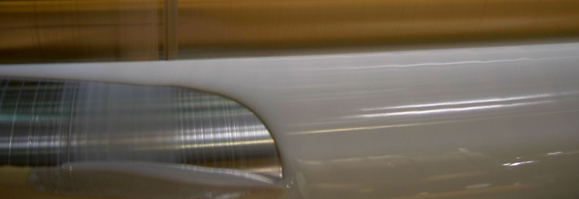 Un primer plano de un trozo de plástico que se enrolla en una máquina.