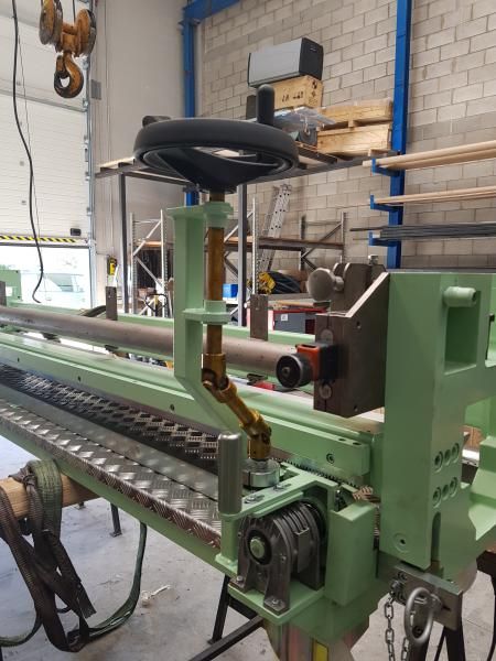 Una máquina verde con un volante encima.