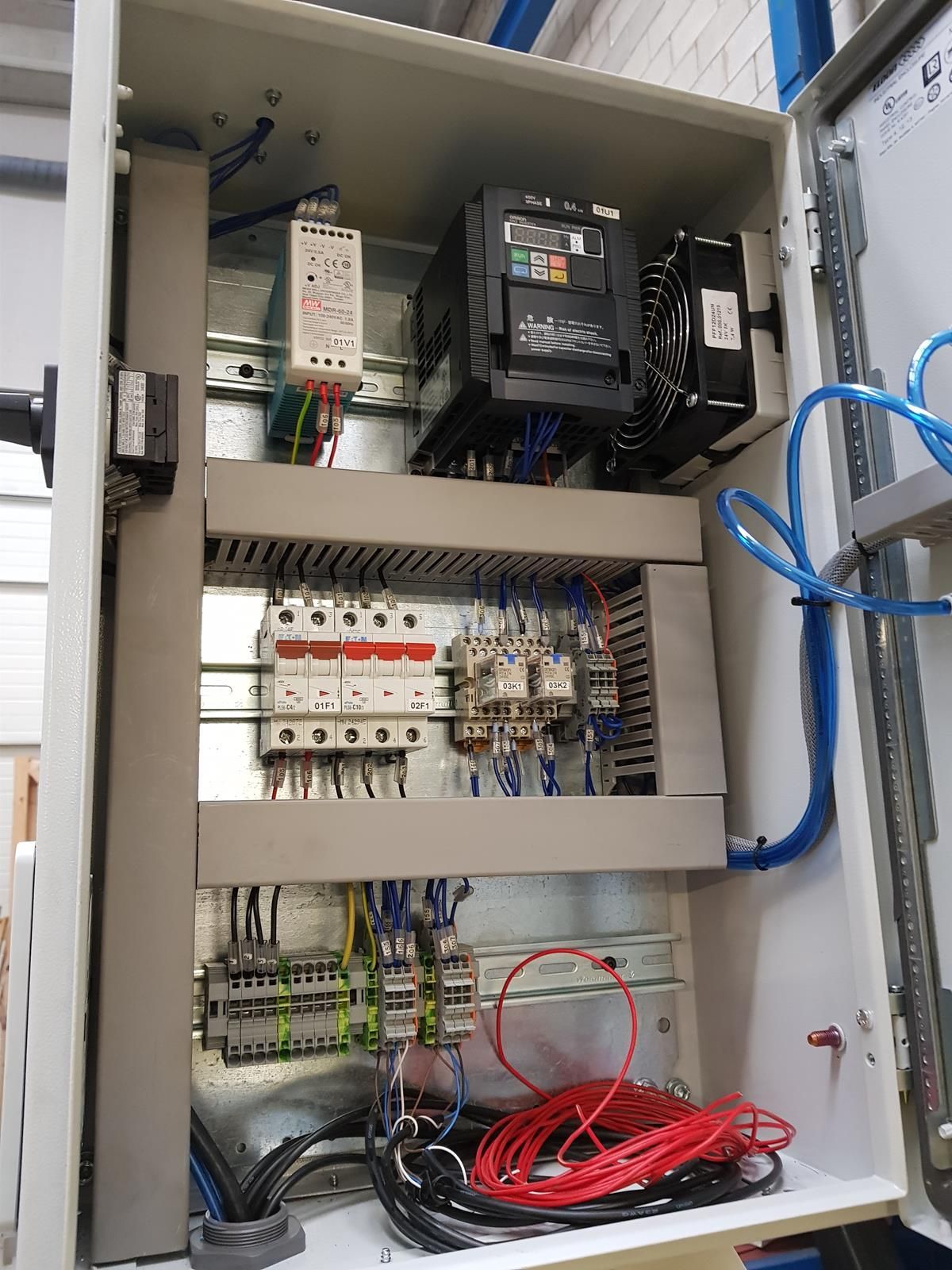 El interior de una caja eléctrica con muchos cables saliendo de ella.