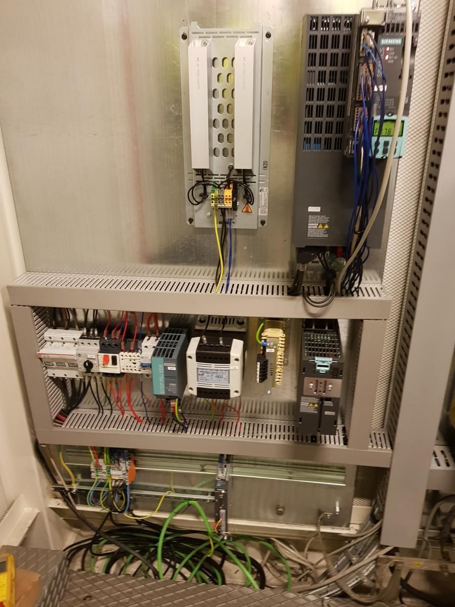 El interior de un panel de control con muchos cables saliendo de él.