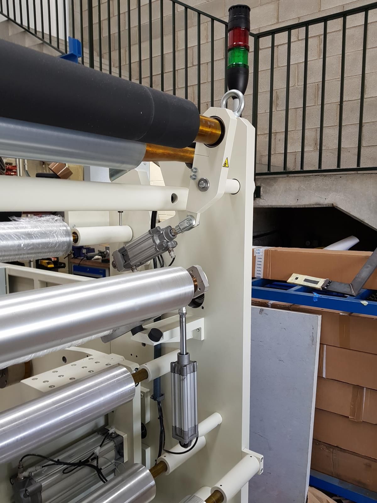 Una máquina está en un almacén al lado de una escalera.