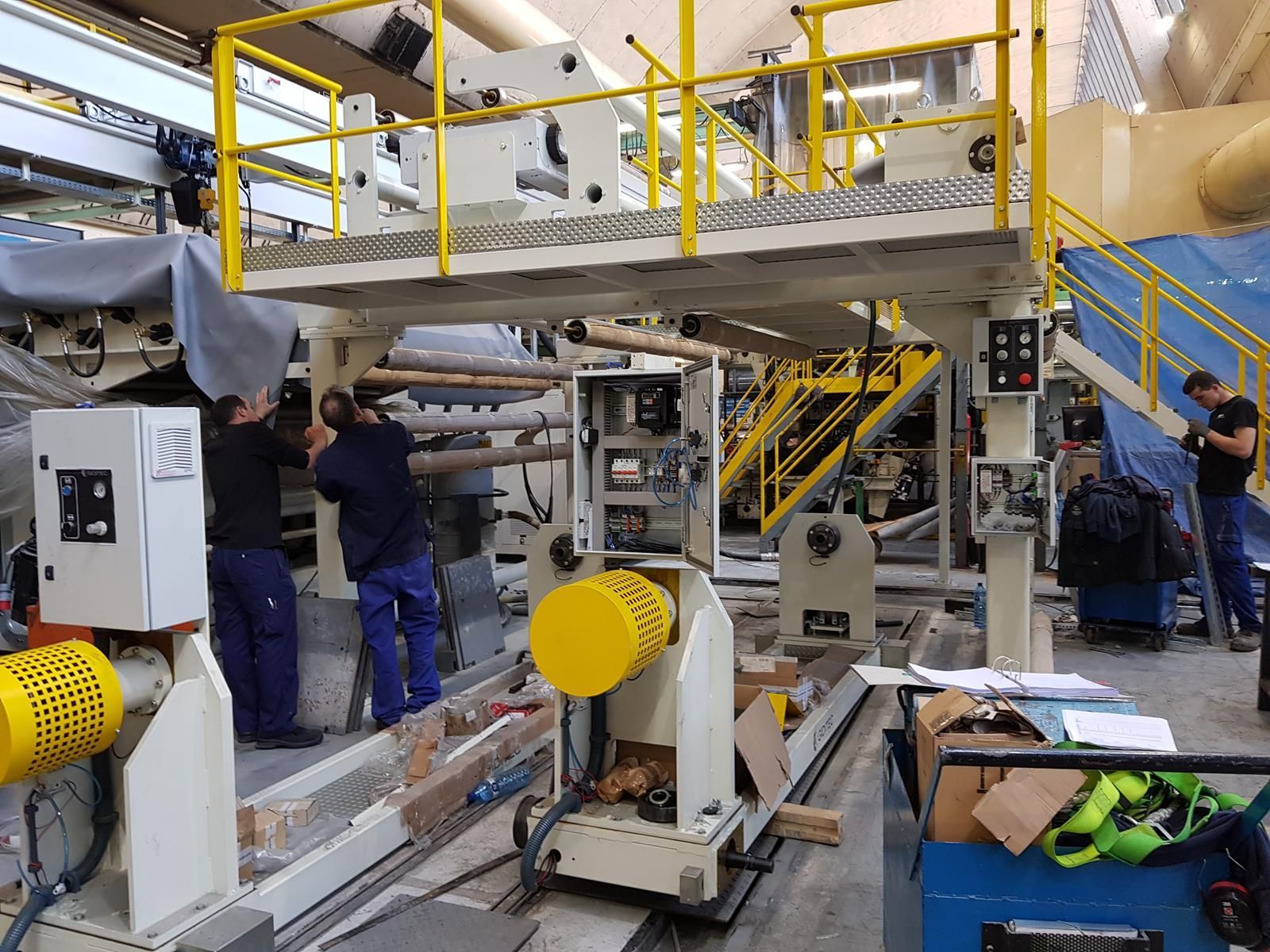 Un grupo de personas está trabajando en una máquina en una fábrica.