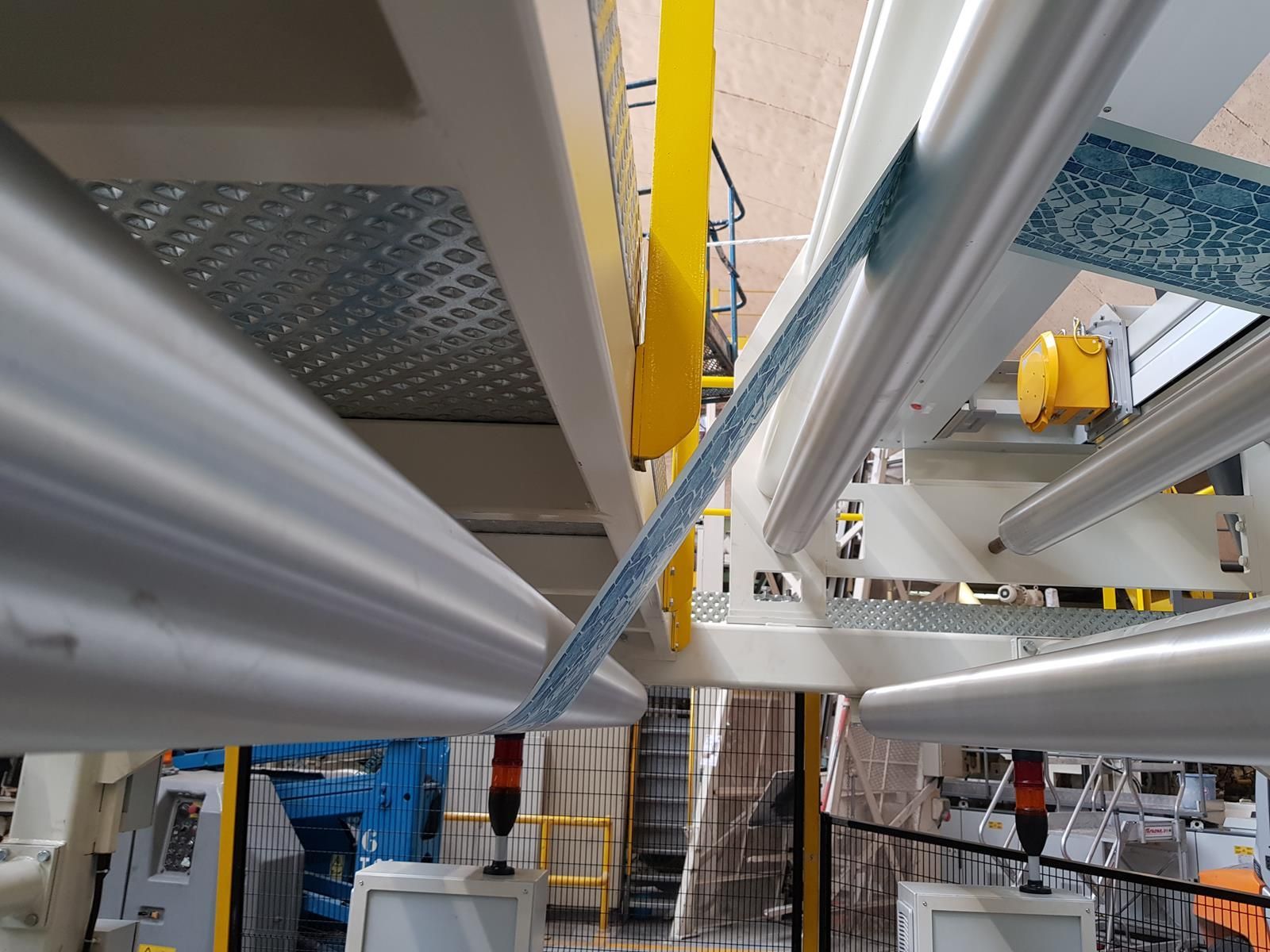 Un primer plano de una máquina en una fábrica con una barandilla amarilla.