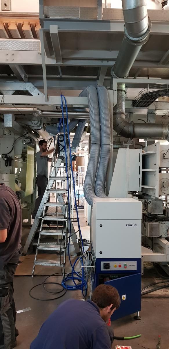 Un grupo de hombres está trabajando en una máquina en una fábrica.