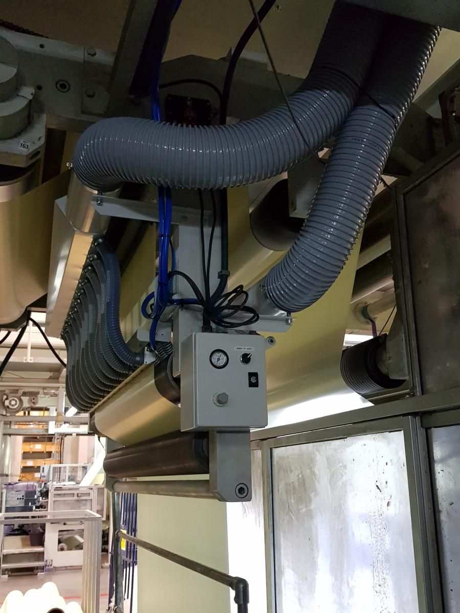 Una manguera cuelga del techo de una máquina en una fábrica.