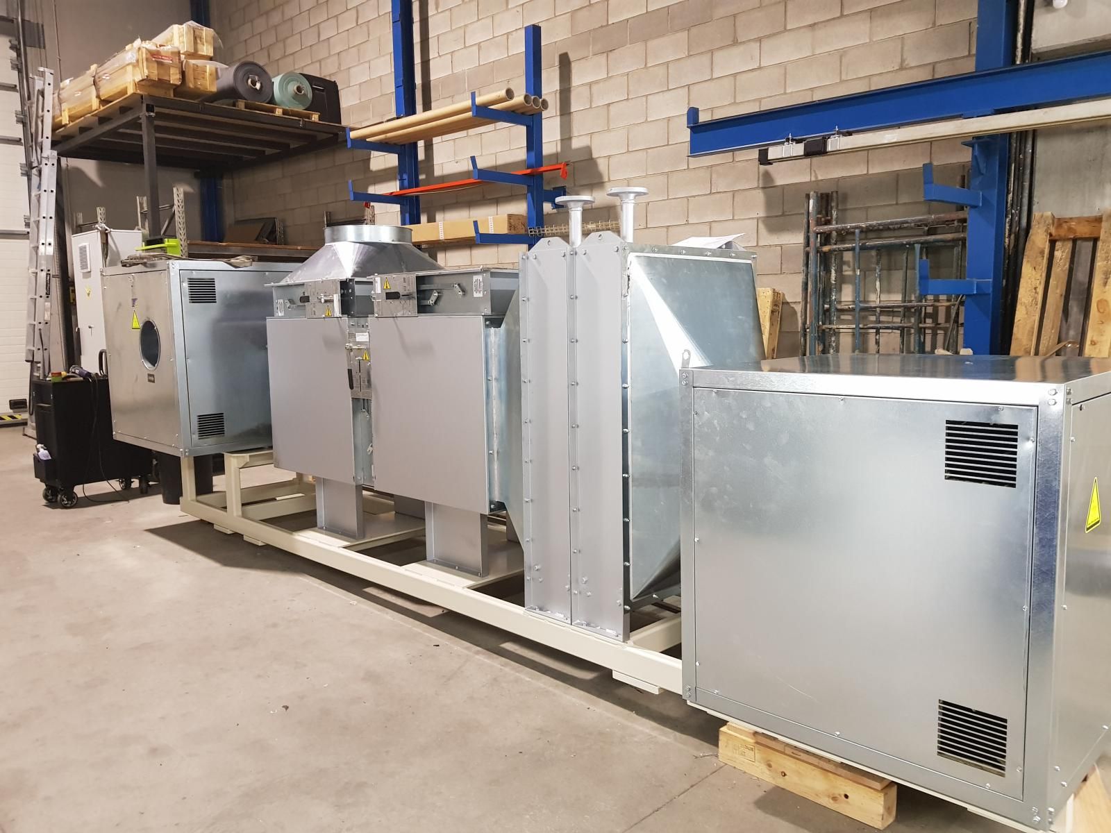 Un montón de cajas de metal se encuentran encima de una paleta de madera en un almacén.