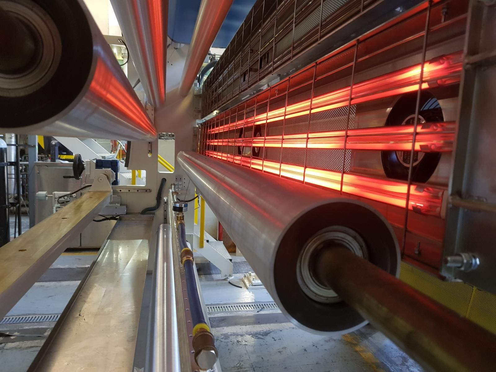 Una fábrica con muchas tuberías y luces rojas.