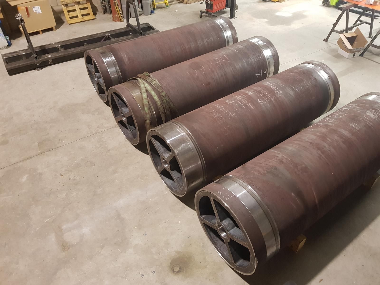 Una fila de tubos de metal colocados uno encima del otro en un almacén.