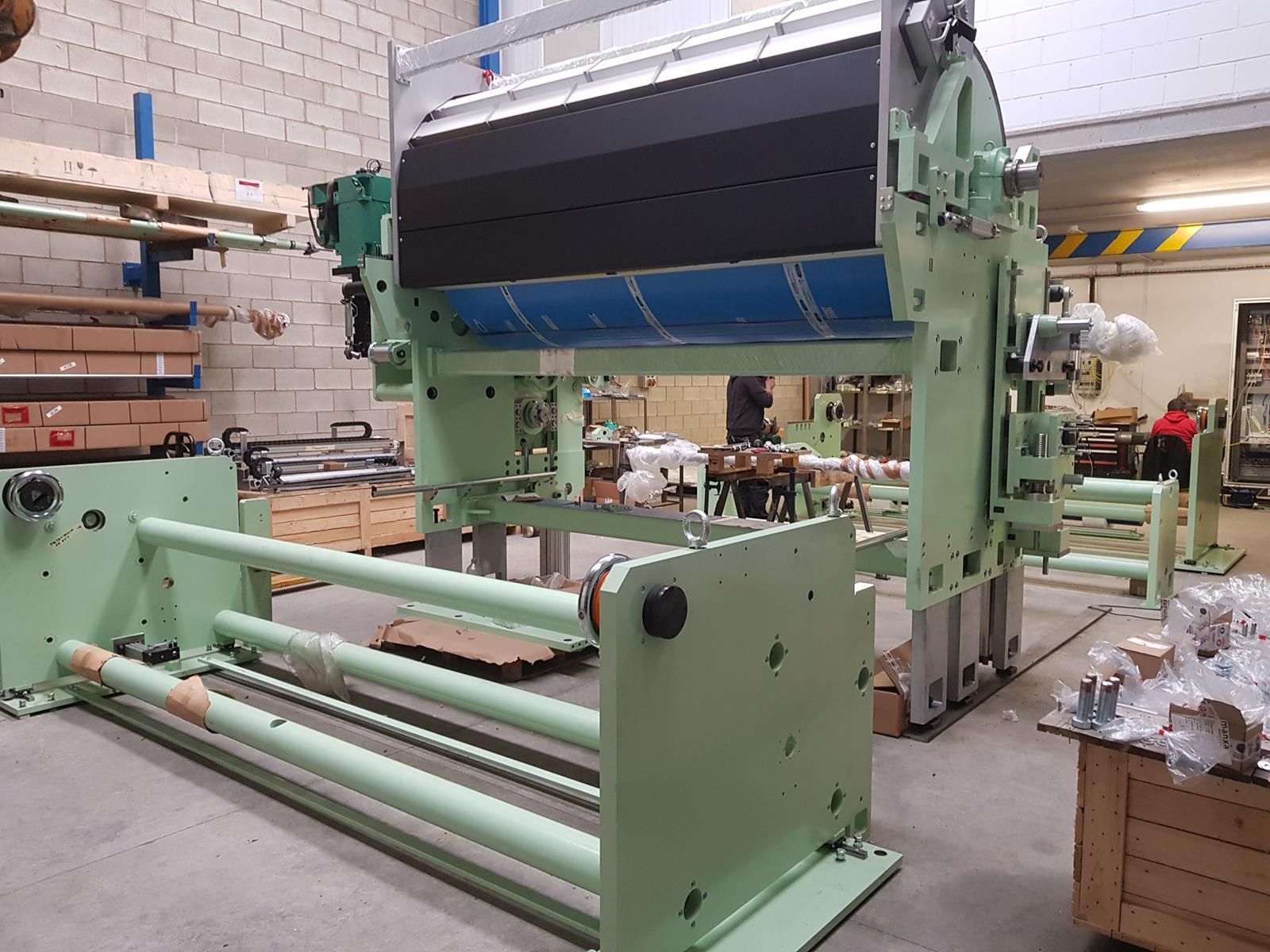 Una gran máquina verde se encuentra en un almacén.