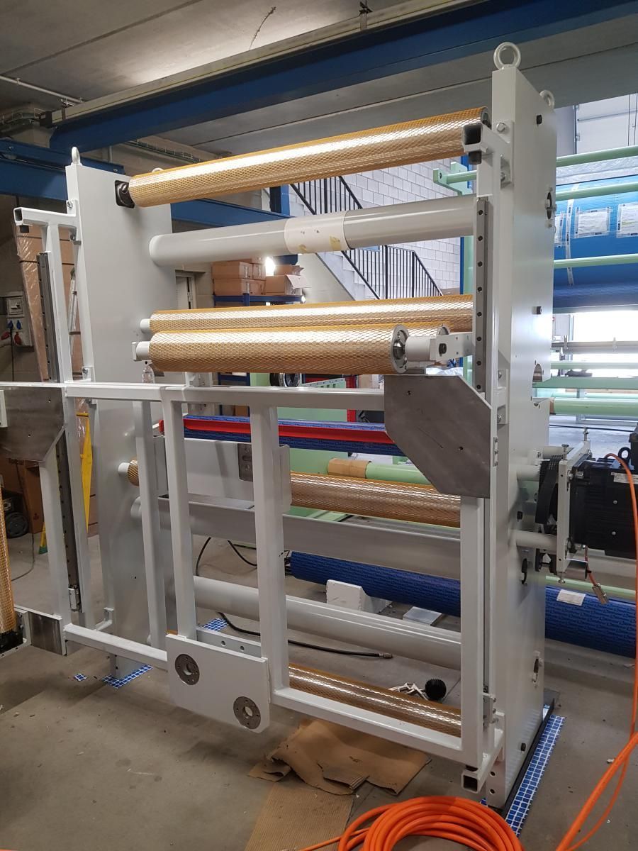 Una máquina está en una habitación con muchos rollos sobre ella.