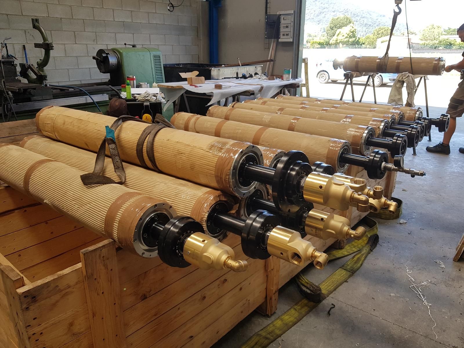Un montón de cilindros se encuentran en una caja de madera en una fábrica.
