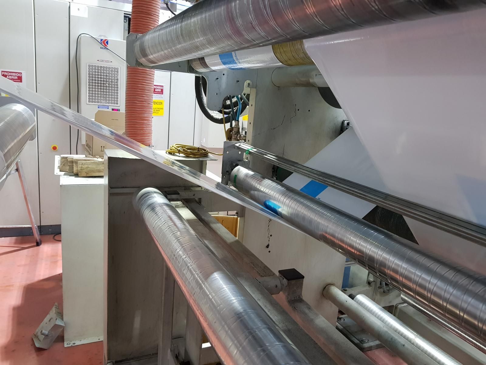 Una máquina está cortando un trozo de papel en una fábrica.