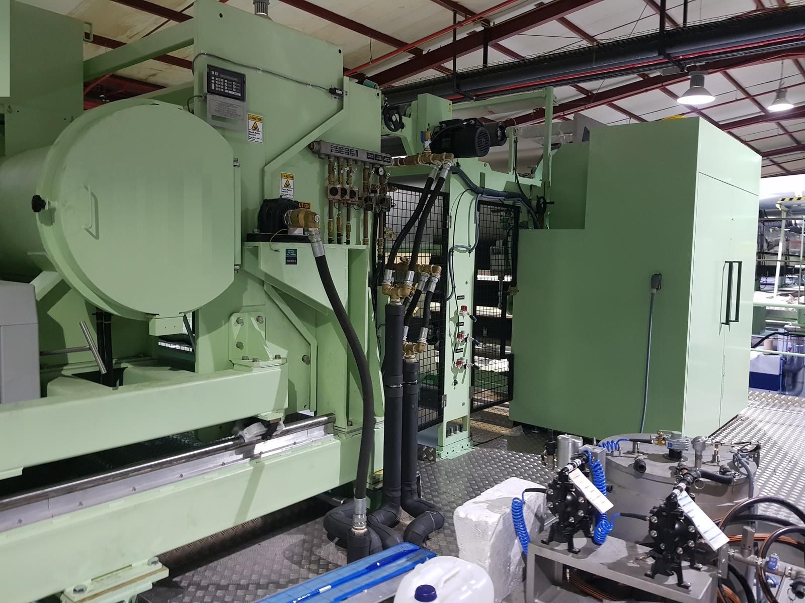 Una gran máquina verde se encuentra en un almacén.