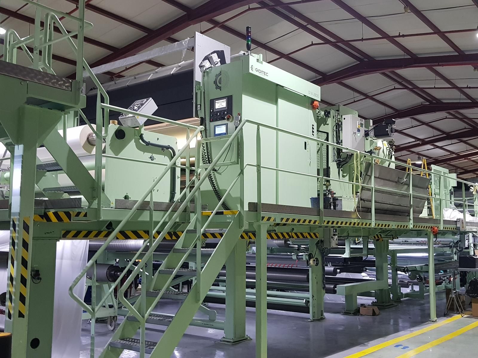 Hay una máquina grande en un almacén con escaleras que conducen a ella.