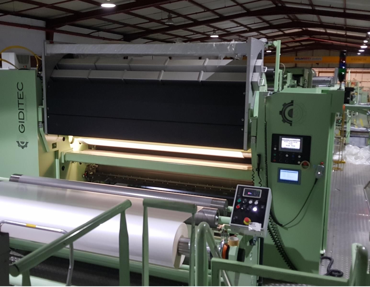 Una gran máquina verde se encuentra en un almacén.