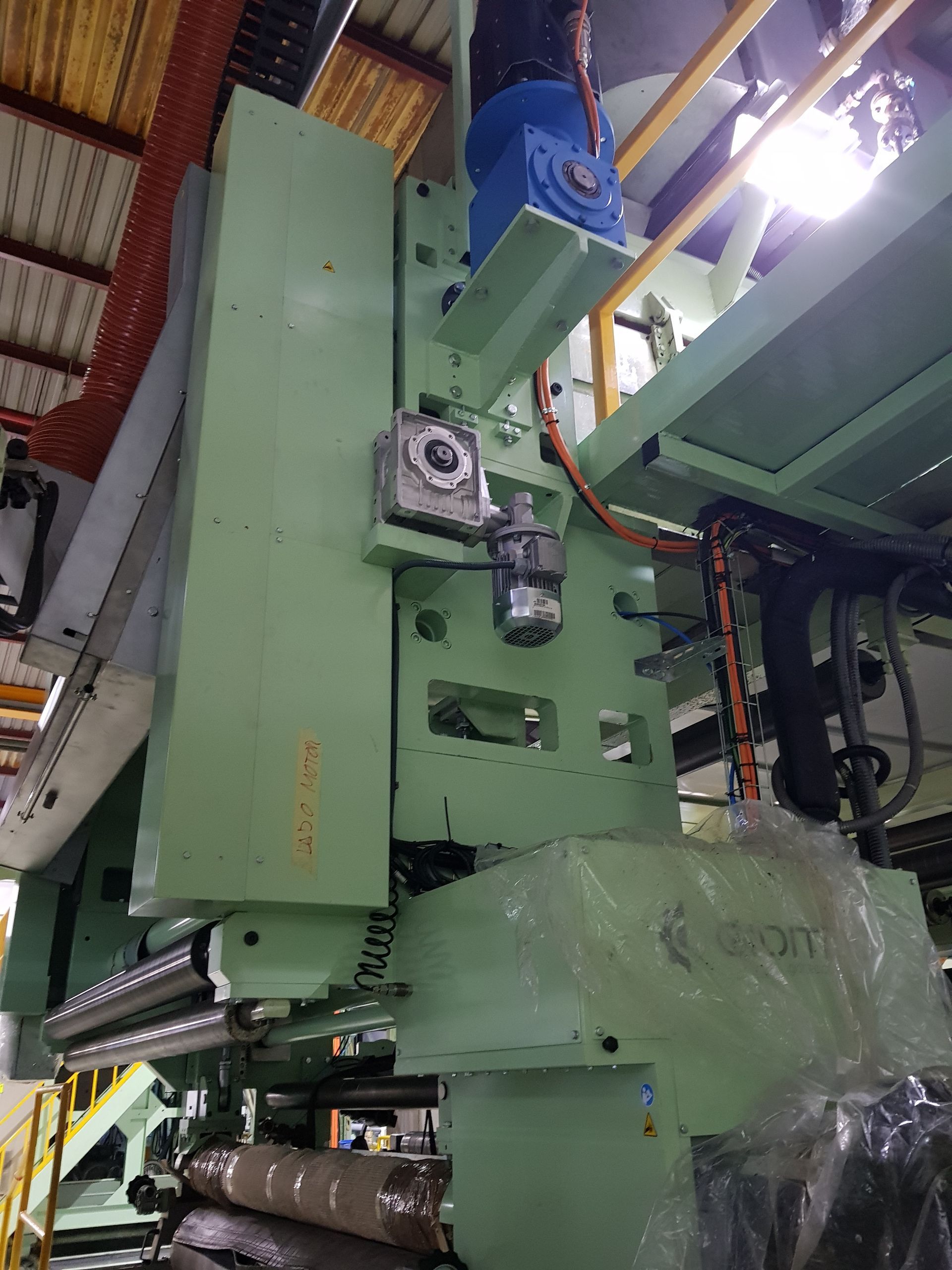 Una gran máquina verde se encuentra en una fábrica.