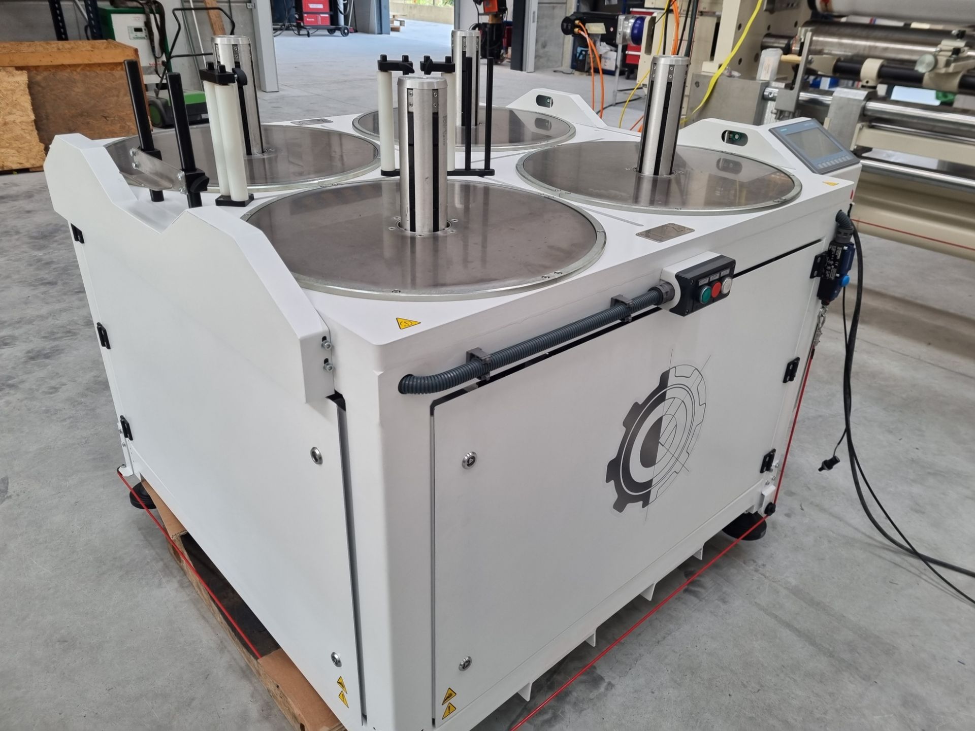 Una gran máquina blanca está colocada encima de una paleta de madera.