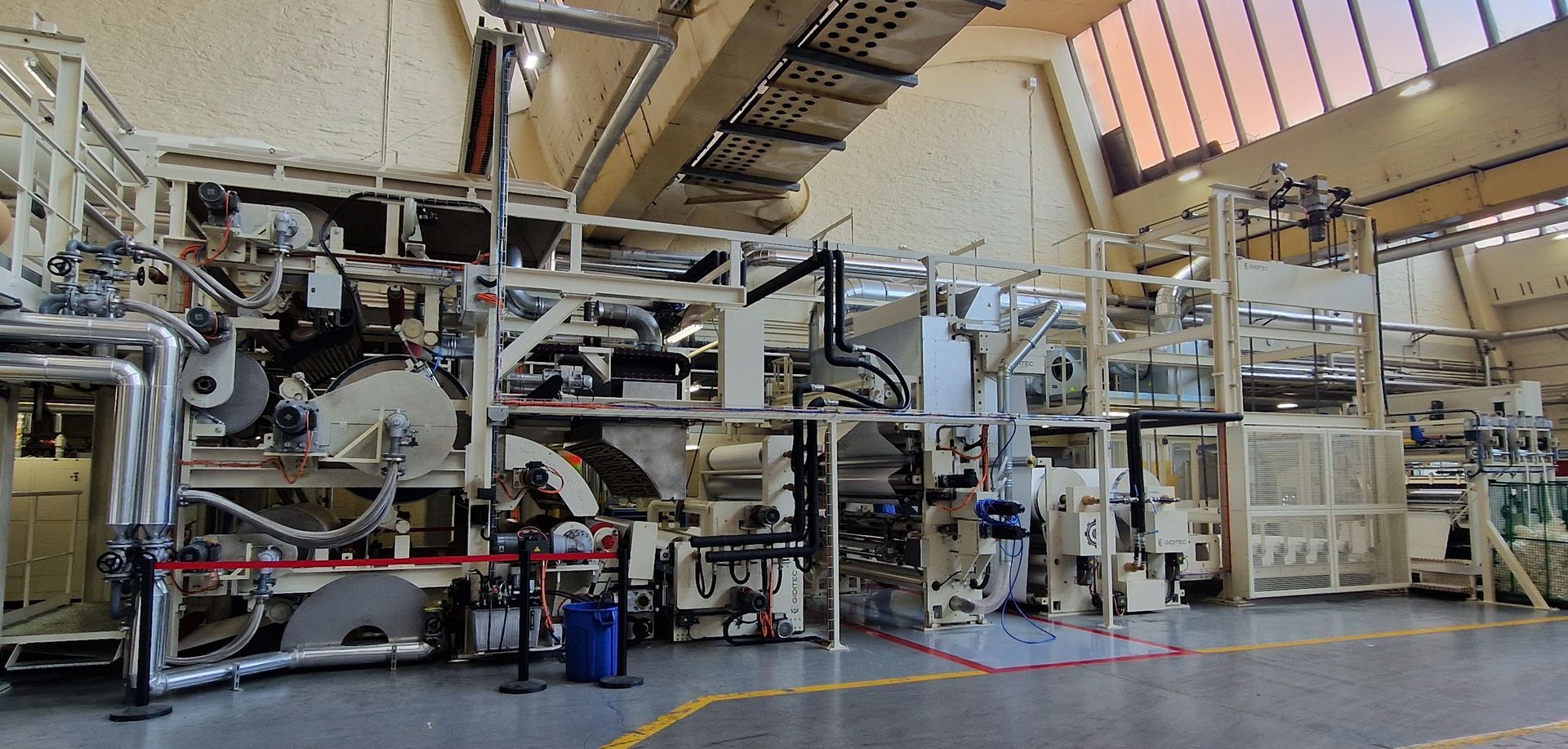 Una gran máquina se encuentra en una gran sala de una fábrica.