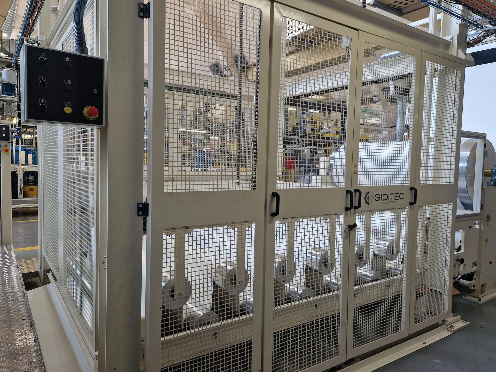 Una valla blanca con un panel de control encima en una fábrica.