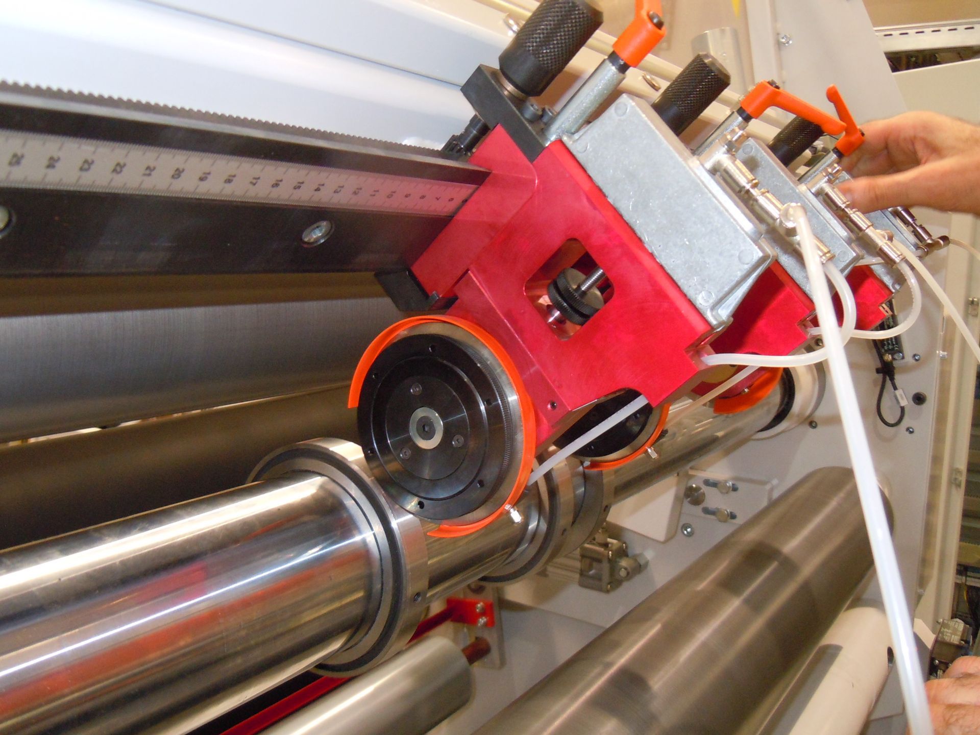 Una persona está trabajando en una máquina con un cilindro rojo.