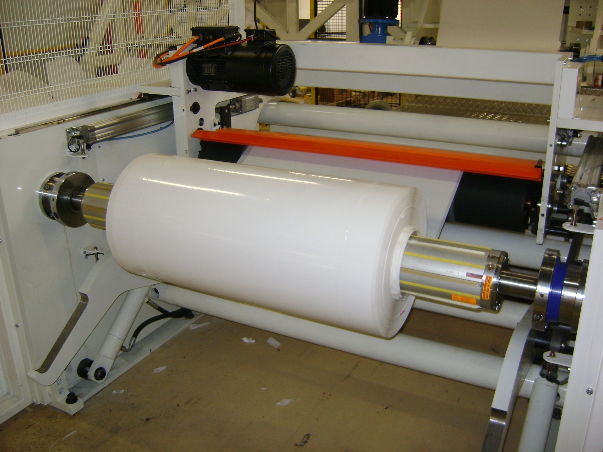 Un gran rollo de papel blanco se enrolla en una máquina.