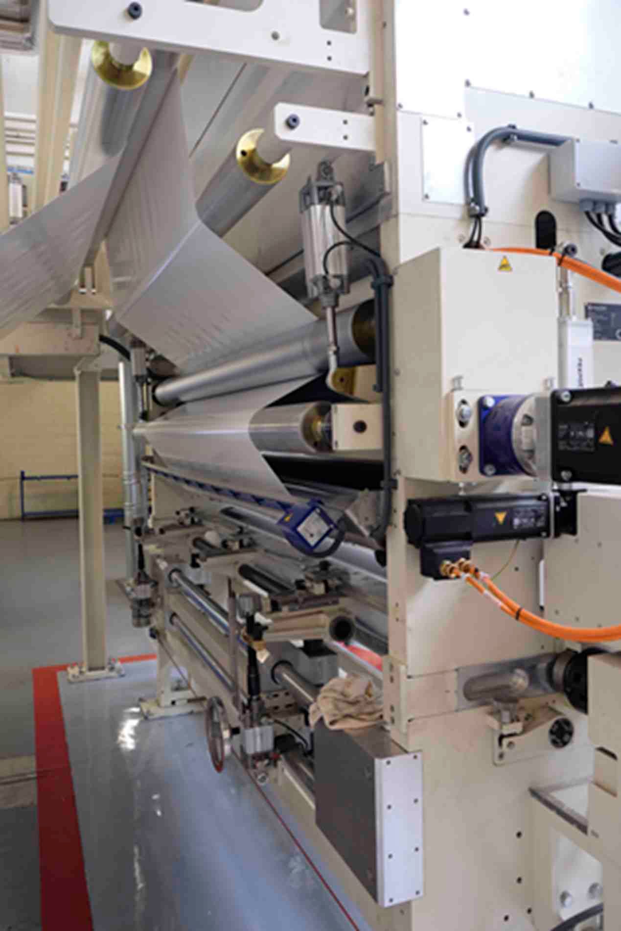 Una máquina grande está en una habitación con una línea roja en el suelo.