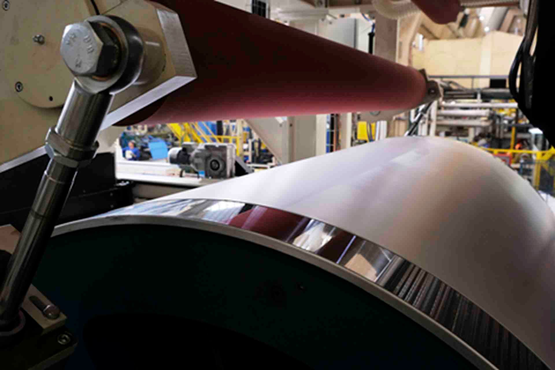 Una máquina está enrollando un trozo de papel en una fábrica.