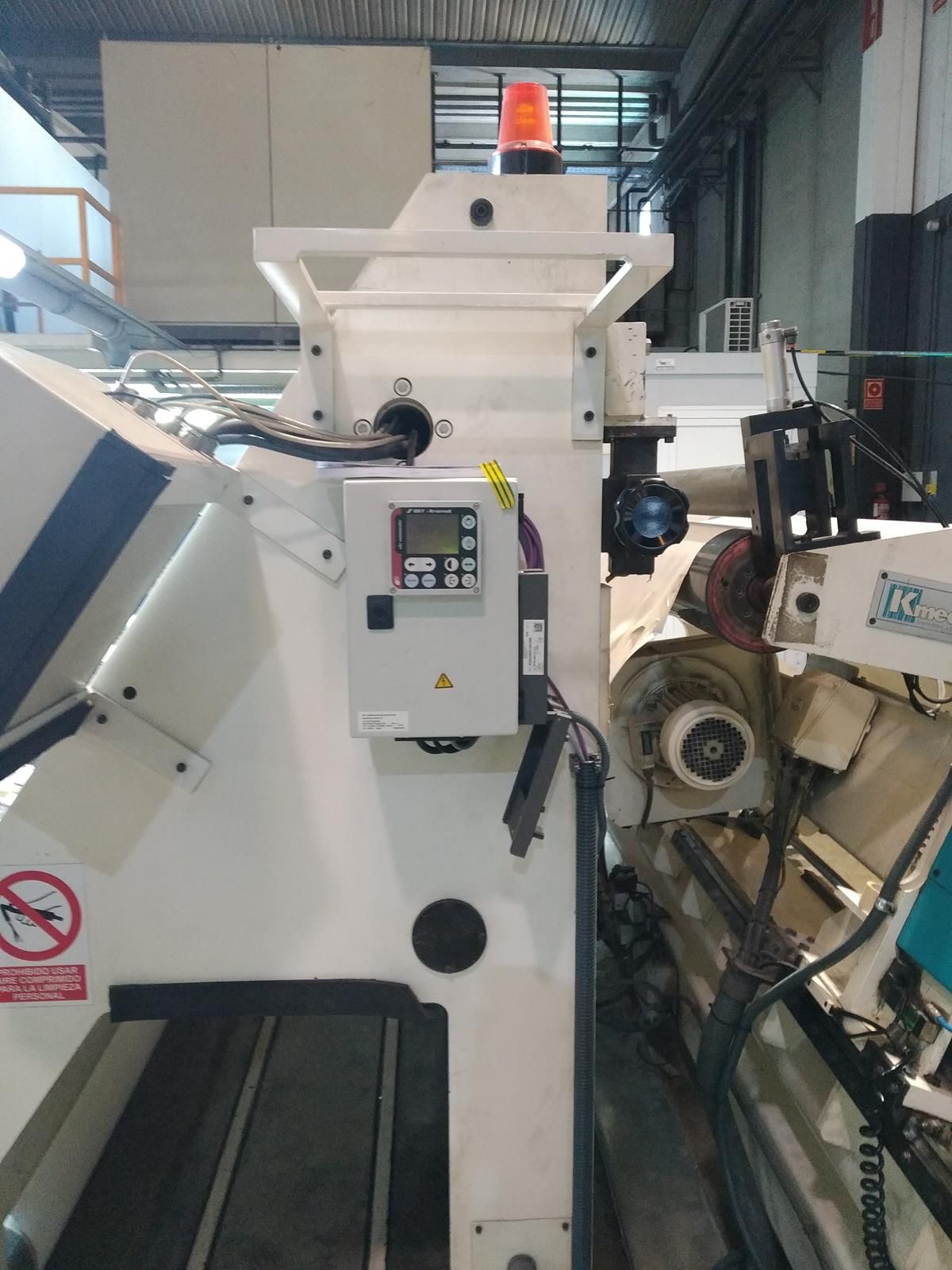 Hay una máquina en un almacén con una luz amarilla encima.