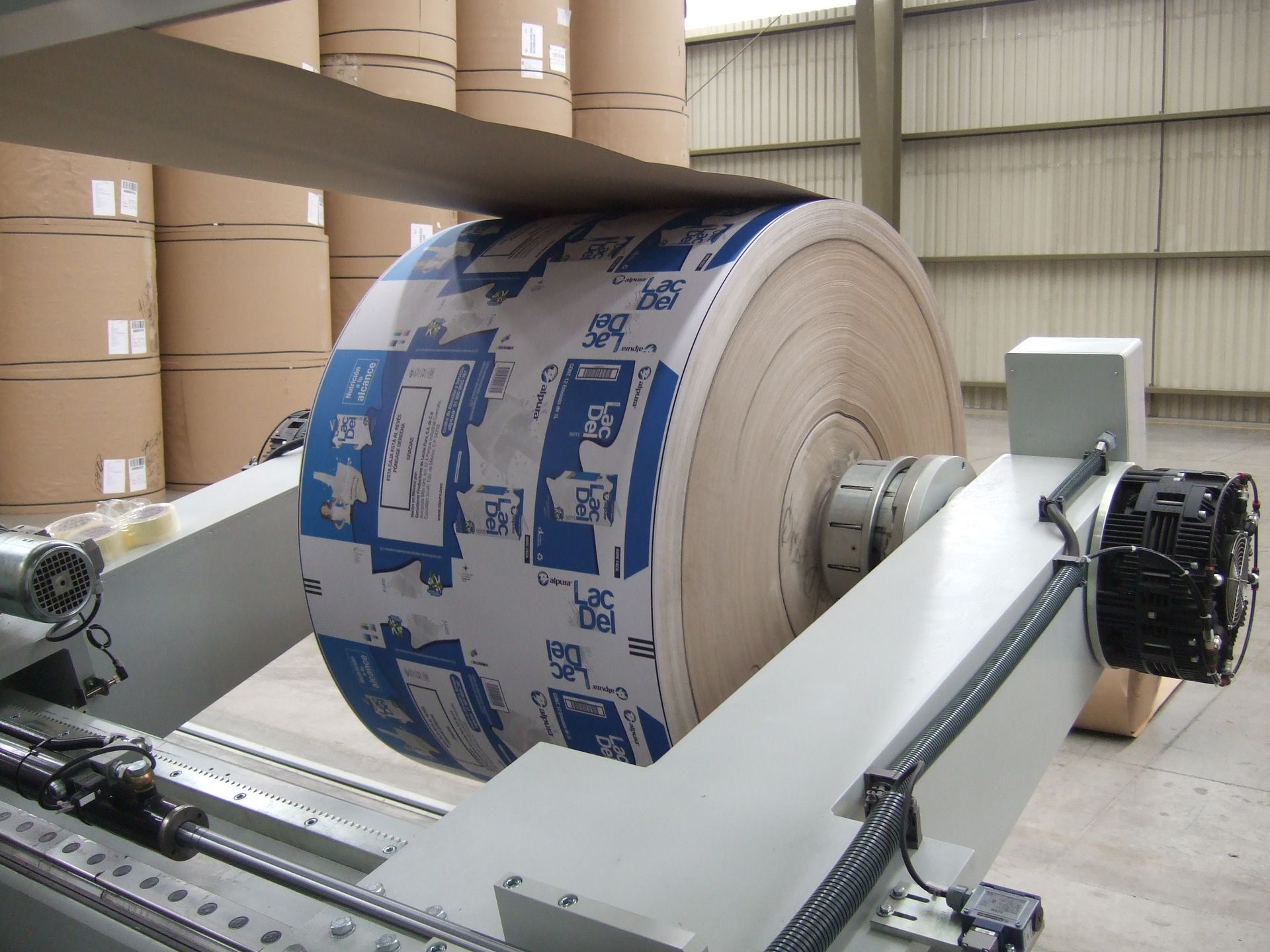 Un rollo grande de papel se está enrollando en una máquina.