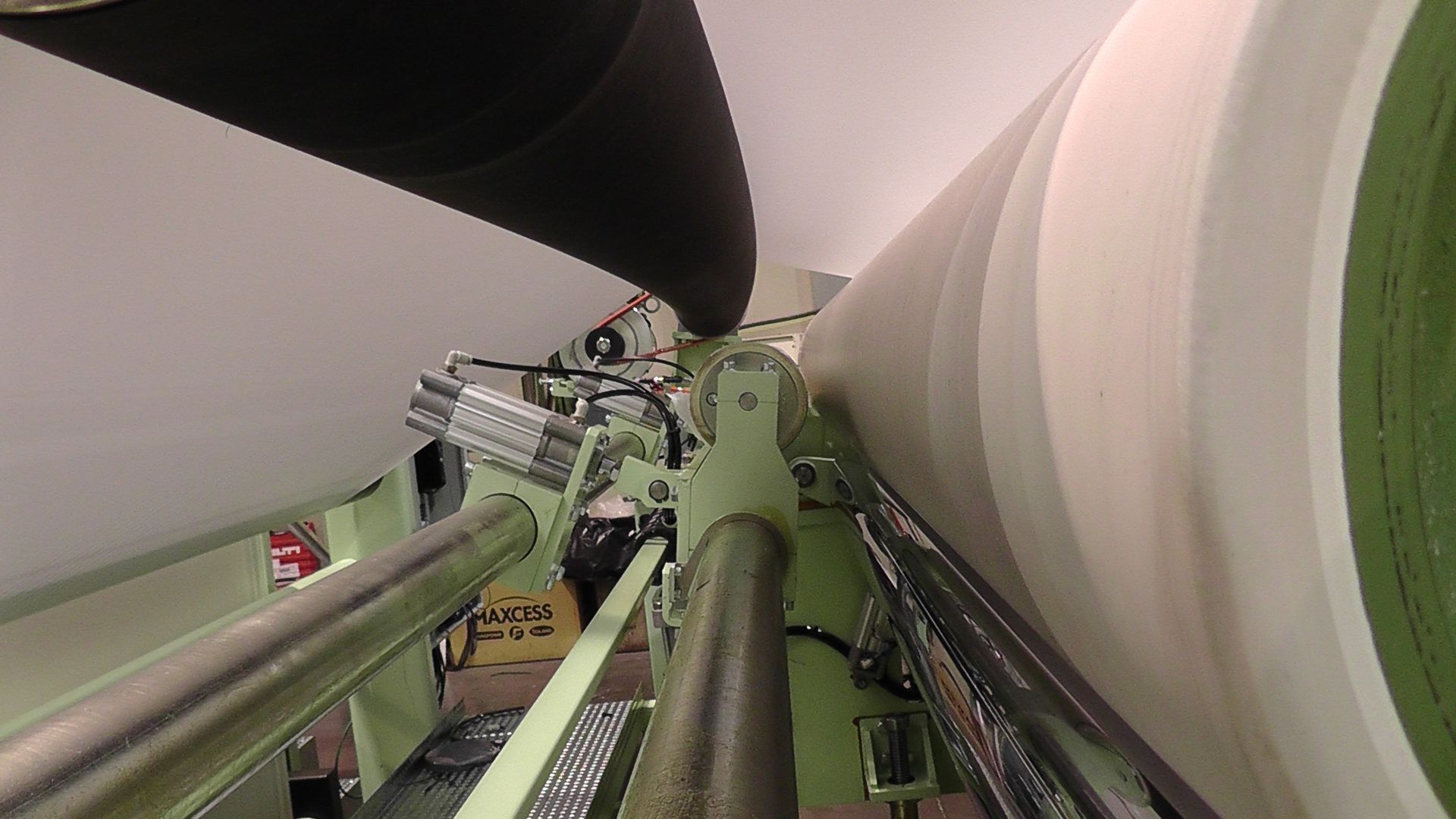 Una máquina está enrollando un trozo grande de papel sobre una cinta transportadora.