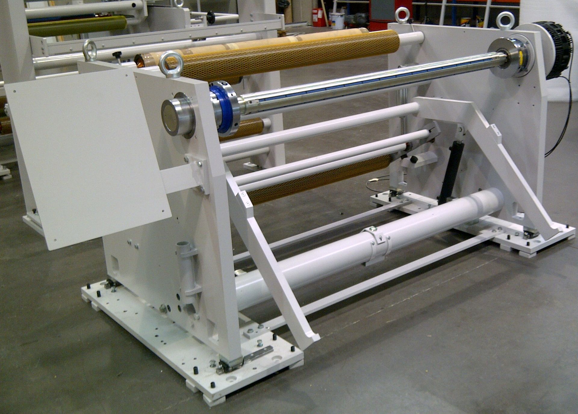 Una gran máquina blanca está sentada sobre un piso de concreto.