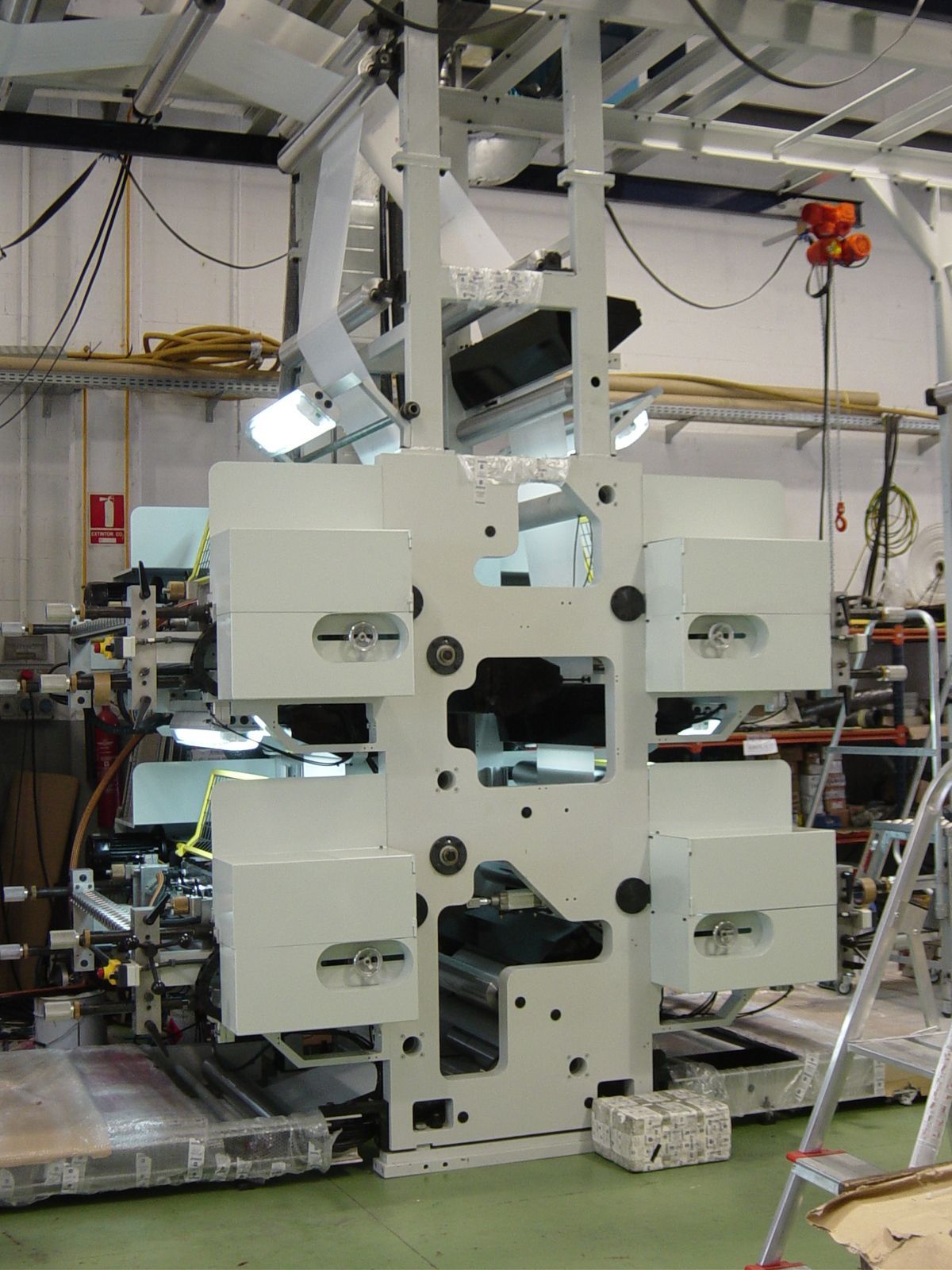 Una máquina en una fábrica con una escalera delante de ella.