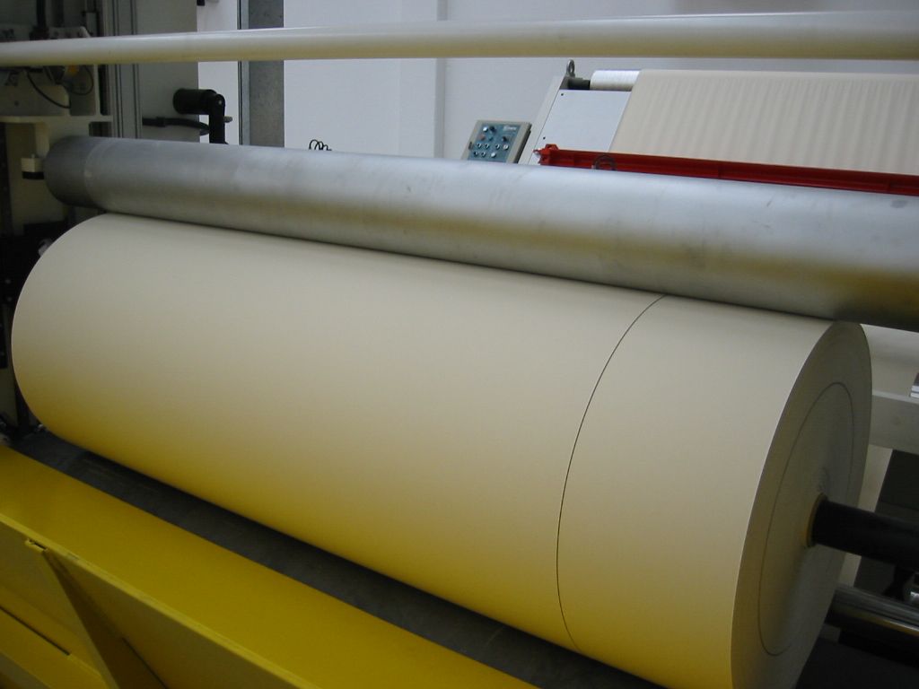 Un rollo grande de papel se está enrollando en una máquina.