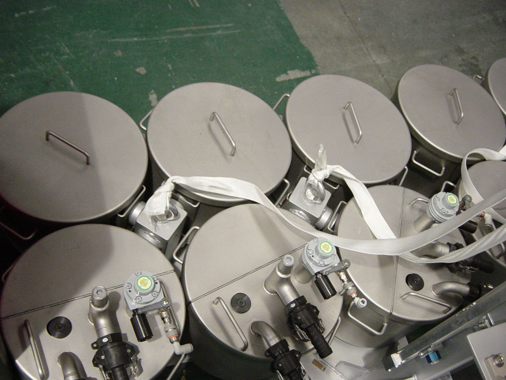 Un montón de contenedores de acero inoxidable están alineados en una fila.