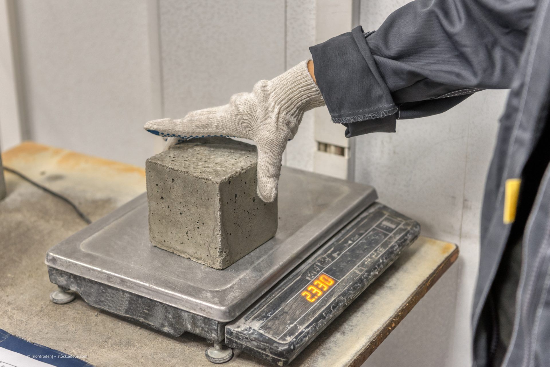 Person wiegt Baumaterial