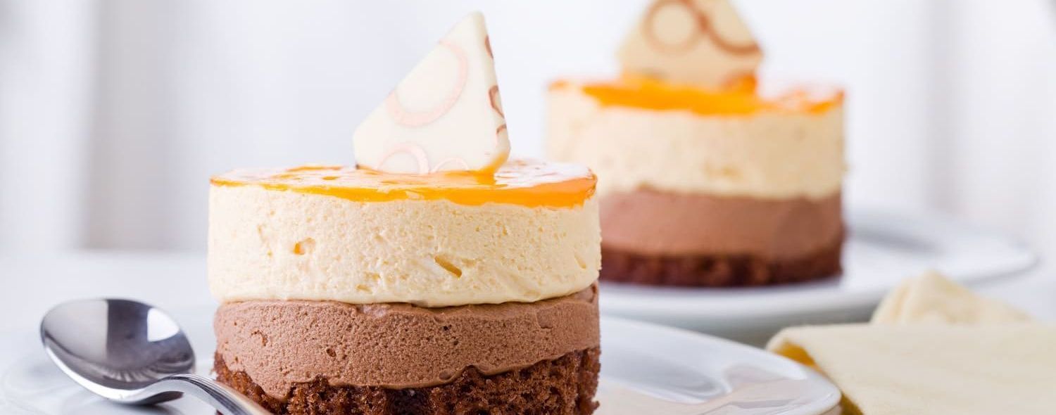 Un primer plano de dos postres en un plato con una cuchara.