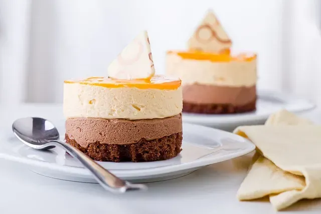 Dos postres en platos con una cuchara sobre una mesa.