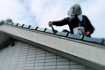 Maalari maalaa talon kattoa