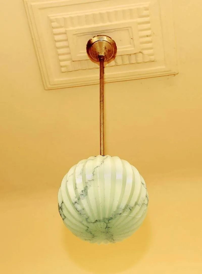 Una lámpara que cuelga del techo con una pantalla de mármol.