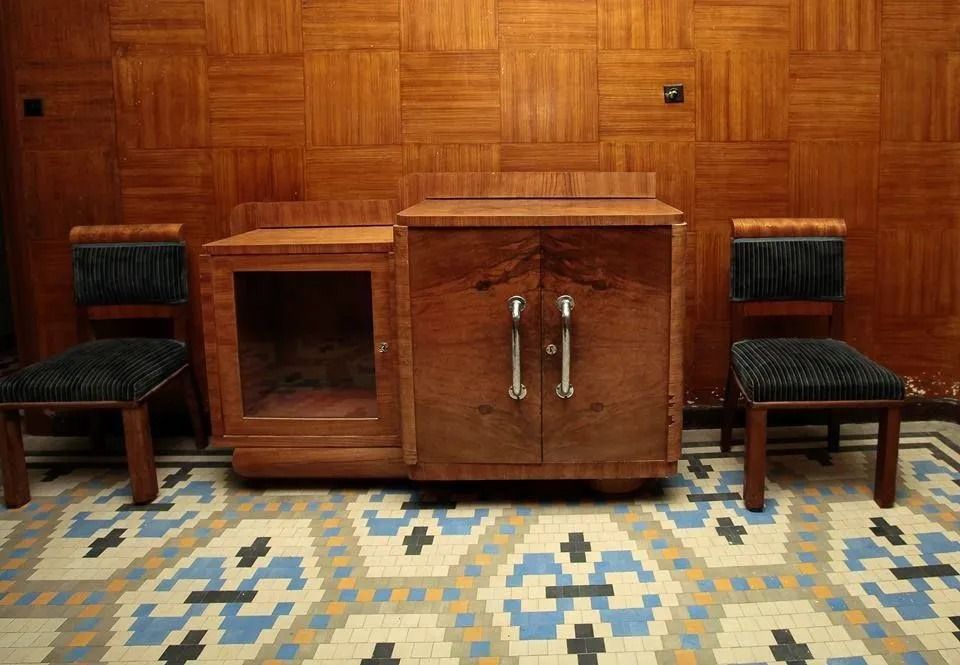 Un armario de madera con dos sillas delante de una pared de madera.
