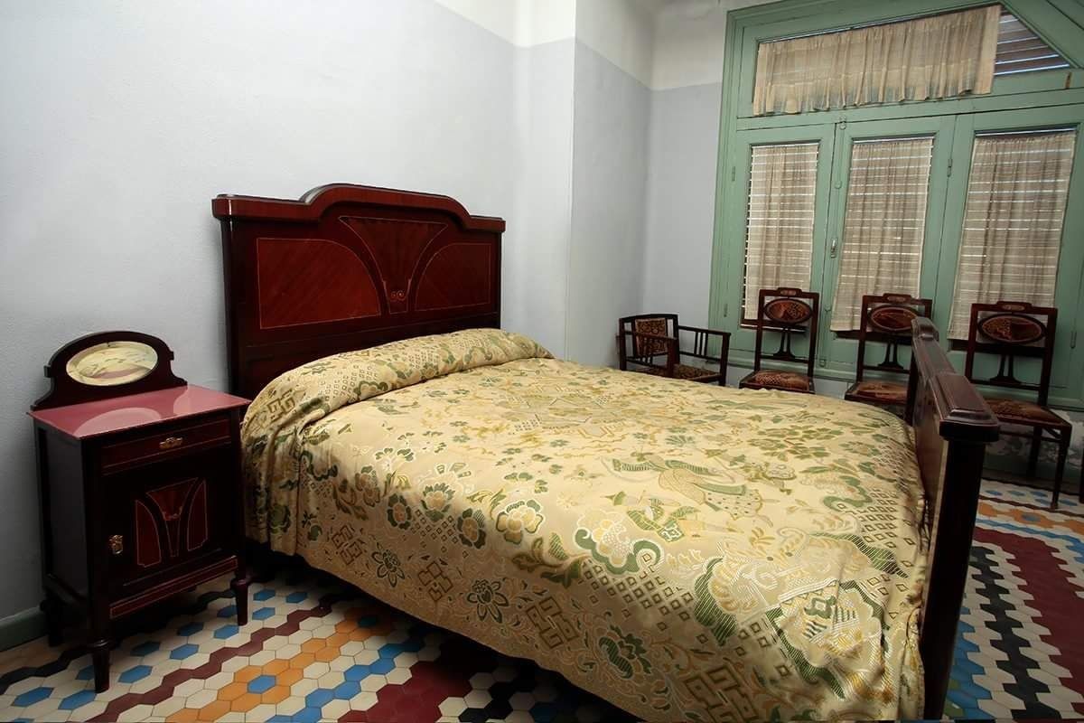 Un dormitorio con una cama, mesita de noche y sillas.