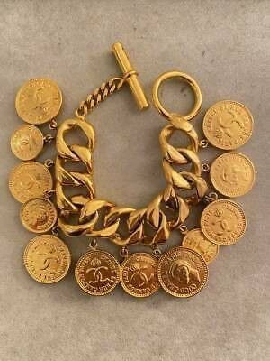 Una pulsera de oro con monedas está sobre una mesa.