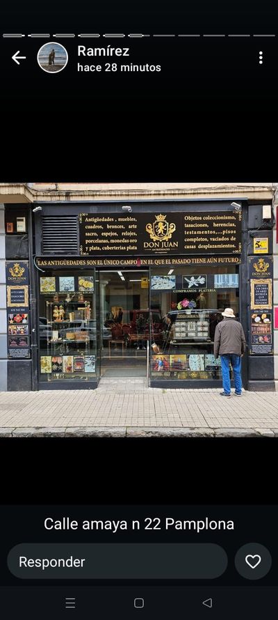 Un hombre con sombrero está parado frente a una tienda.