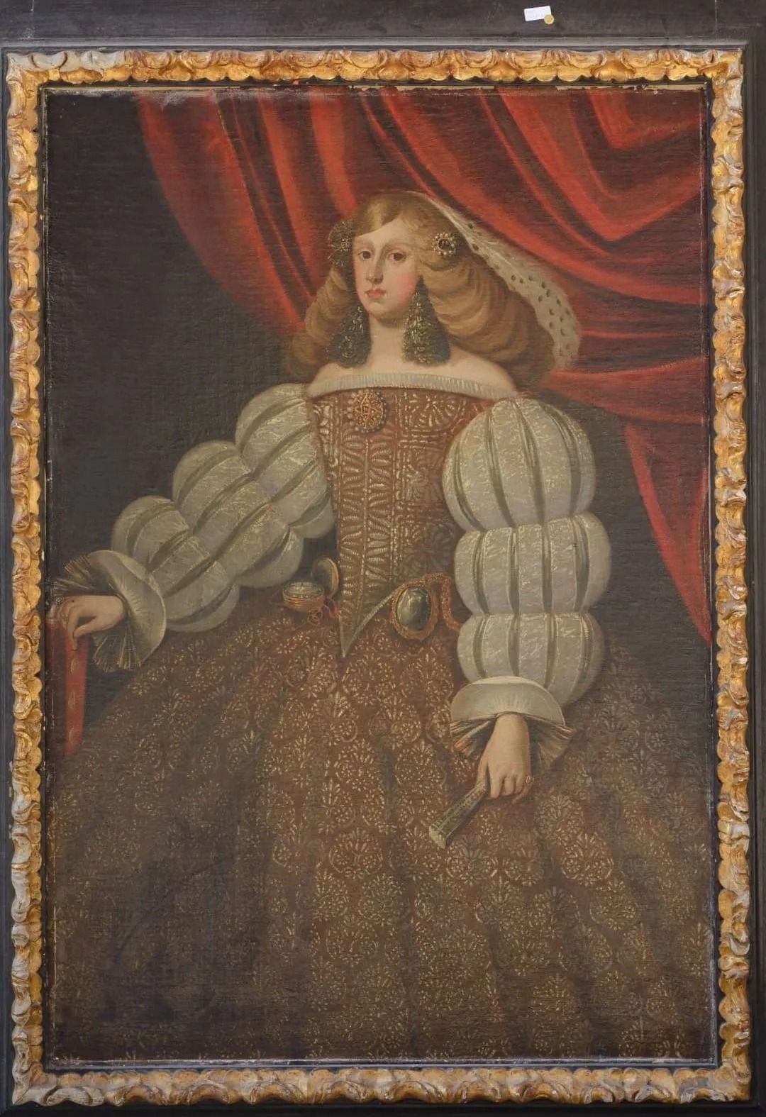 Una pintura de una mujer con un vestido y una cortina roja detrás de ella.